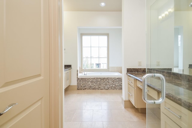 bathroom with vanity, tiled bath, and tile patterned floors