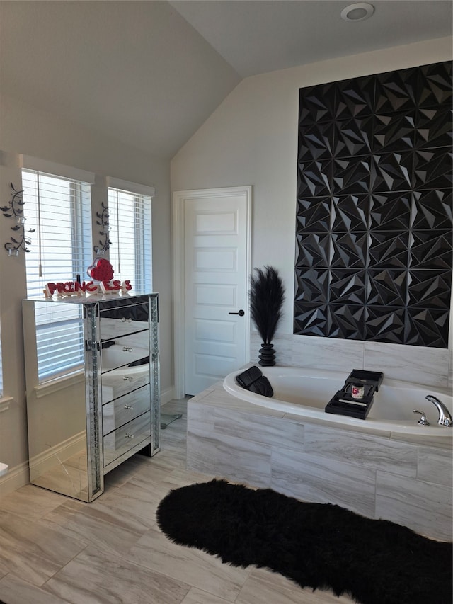 bathroom featuring tiled bath, tile patterned floors, and lofted ceiling