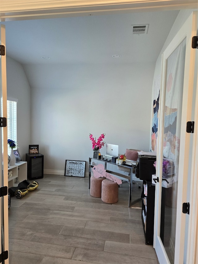 office with light hardwood / wood-style flooring and vaulted ceiling