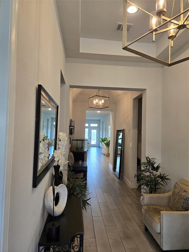 corridor featuring hardwood / wood-style floors and an inviting chandelier