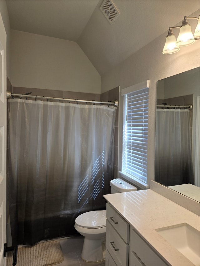 bathroom with tile patterned floors, vanity, lofted ceiling, and toilet