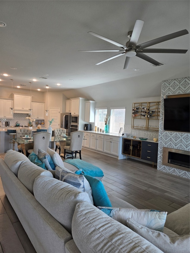 living room featuring a fireplace, hardwood / wood-style floors, and ceiling fan