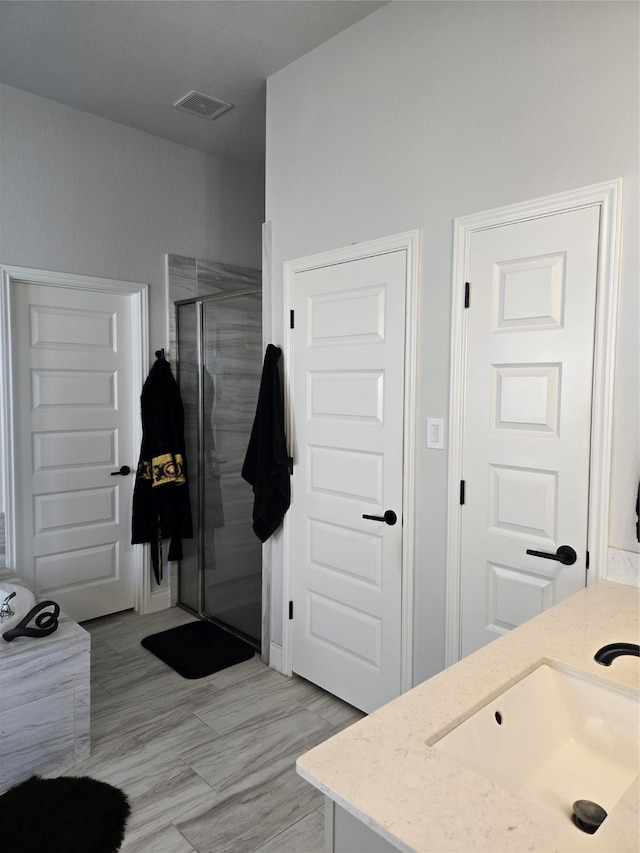 bathroom with vanity and a shower with shower door