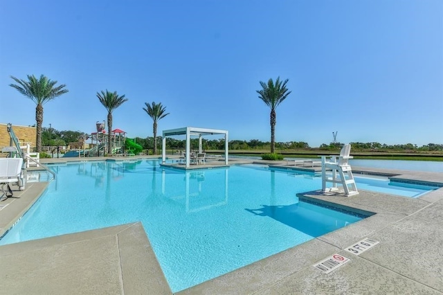 view of swimming pool featuring a water view and a patio