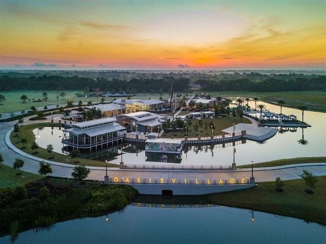 aerial view at dusk featuring a water view