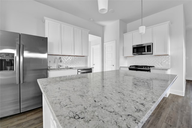 kitchen featuring appliances with stainless steel finishes, dark hardwood / wood-style floors, white cabinetry, and pendant lighting