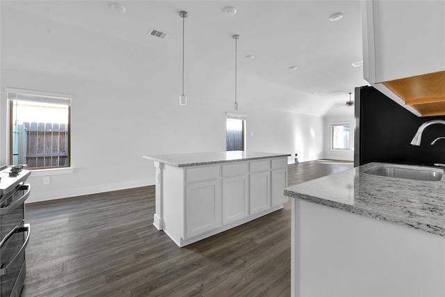 kitchen with lofted ceiling, white cabinetry, a healthy amount of sunlight, and decorative light fixtures