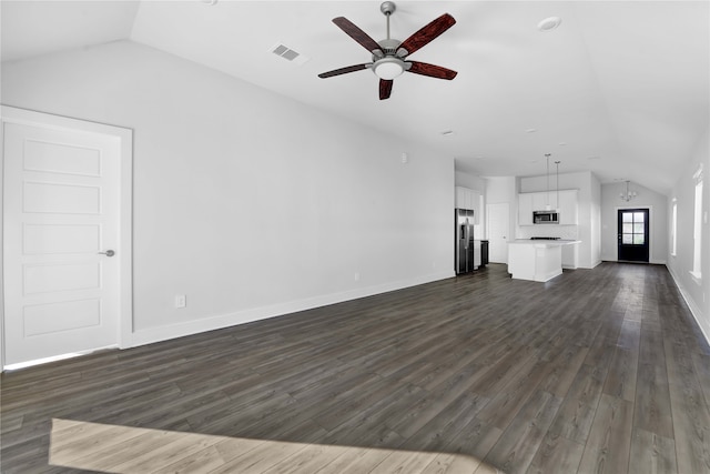 unfurnished living room featuring ceiling fan with notable chandelier, dark wood-type flooring, and vaulted ceiling