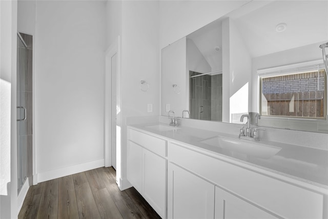 bathroom featuring hardwood / wood-style floors, vanity, vaulted ceiling, and walk in shower