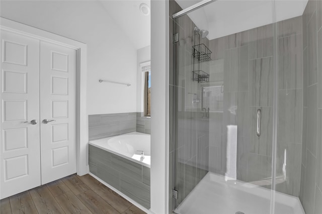 bathroom featuring hardwood / wood-style flooring, plus walk in shower, and vaulted ceiling