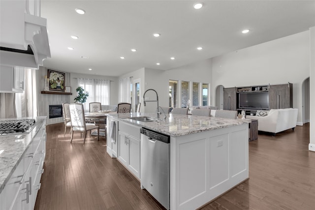 kitchen with white cabinets, a center island with sink, sink, dark hardwood / wood-style flooring, and stainless steel appliances