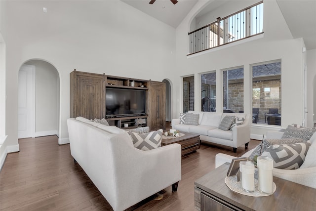 living room with ceiling fan, plenty of natural light, high vaulted ceiling, and dark wood-type flooring