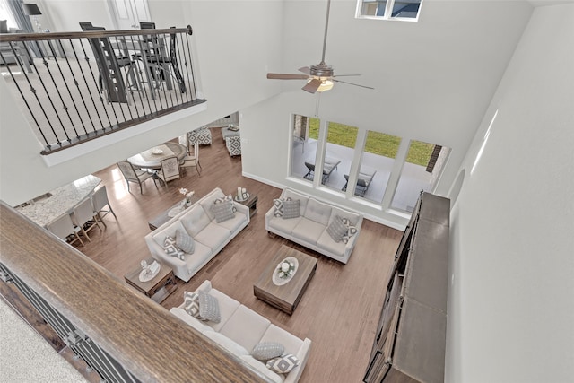 living room with wood-type flooring, high vaulted ceiling, and ceiling fan