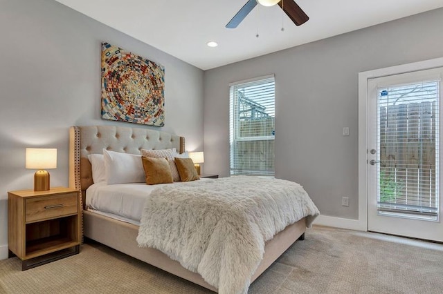 carpeted bedroom featuring access to outside, multiple windows, and ceiling fan