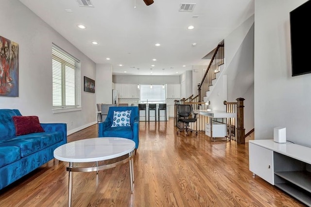 living room featuring ceiling fan and light wood-type flooring