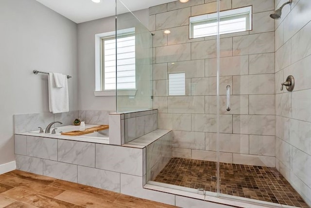 bathroom with hardwood / wood-style flooring, a healthy amount of sunlight, and independent shower and bath