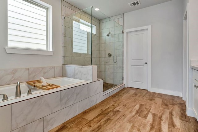 bathroom featuring separate shower and tub, hardwood / wood-style floors, and vanity