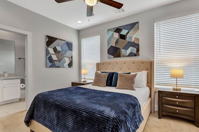 carpeted bedroom featuring ensuite bath and ceiling fan