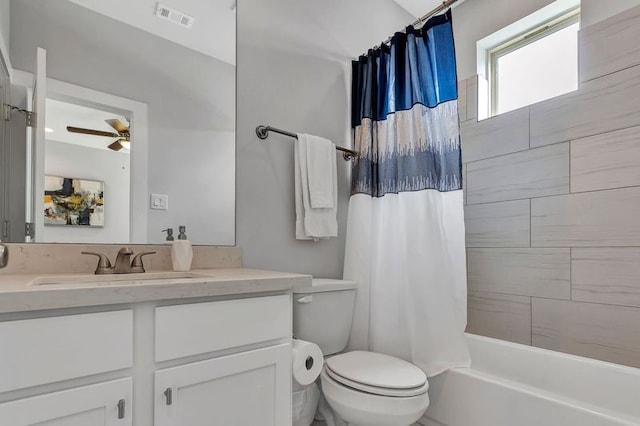 full bathroom featuring toilet, vanity, shower / tub combo with curtain, and ceiling fan