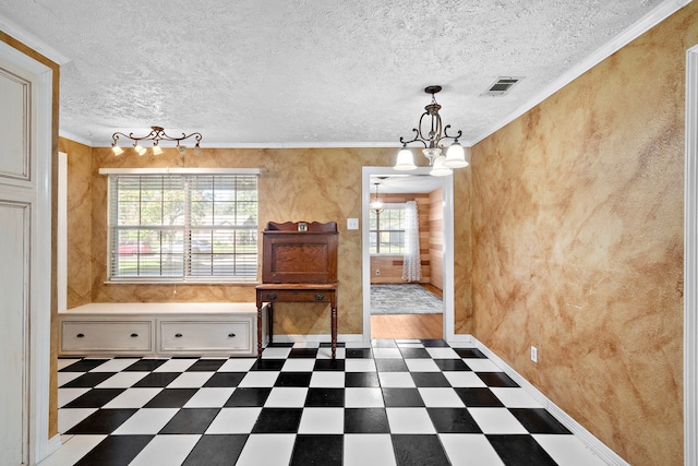 unfurnished dining area with crown molding, a chandelier, and a textured ceiling