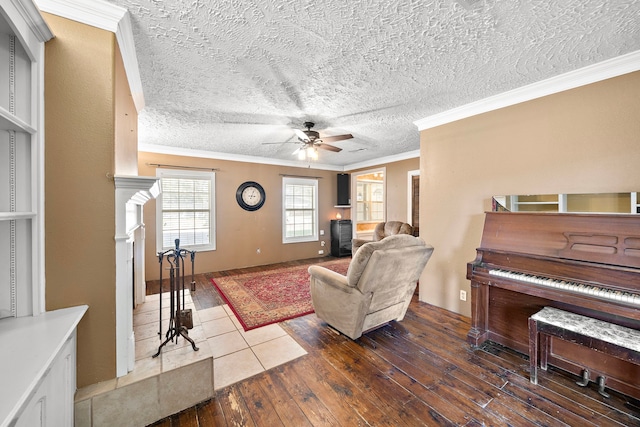 living room featuring a textured ceiling, crown molding, ceiling fan, and dark wood-type flooring