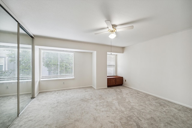 unfurnished bedroom featuring ceiling fan, a closet, and light carpet