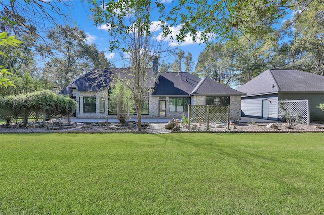 back of property with a lawn, an outbuilding, and a patio