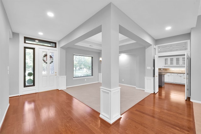 foyer with wood-type flooring and ornate columns