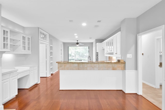 kitchen featuring white cabinetry, sink, ceiling fan, kitchen peninsula, and wood-type flooring