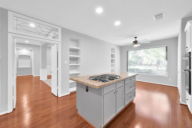 kitchen featuring a center island, dark hardwood / wood-style floors, white cabinetry, and stainless steel gas cooktop