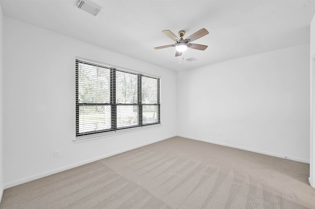 spare room featuring light carpet and ceiling fan