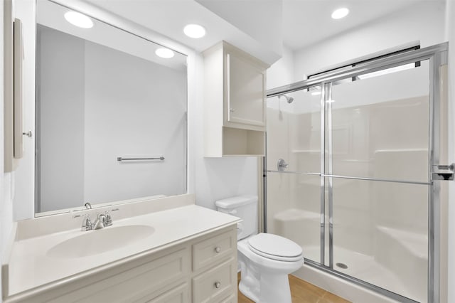 bathroom featuring tile patterned floors, toilet, vanity, and walk in shower