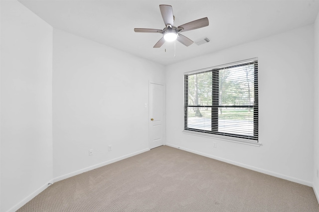 carpeted spare room with ceiling fan