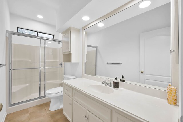 bathroom featuring toilet, tile patterned flooring, vanity, and walk in shower