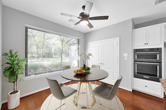 dining room with ceiling fan and dark wood-type flooring