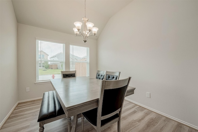 dining space with light hardwood / wood-style flooring, lofted ceiling, and an inviting chandelier