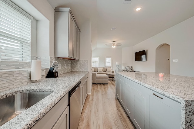 kitchen with dishwasher, gray cabinets, light hardwood / wood-style floors, and backsplash