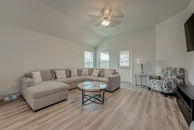 living room featuring light hardwood / wood-style floors, vaulted ceiling, and ceiling fan