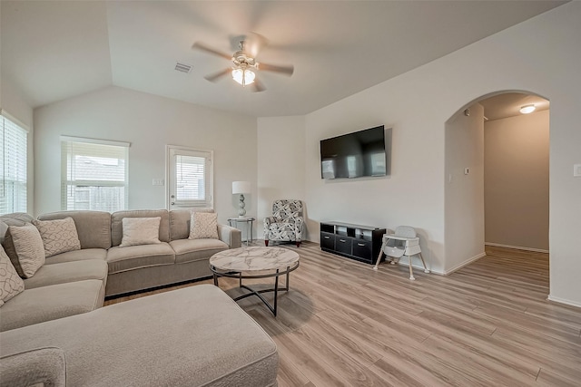 living room featuring ceiling fan, light hardwood / wood-style flooring, and vaulted ceiling