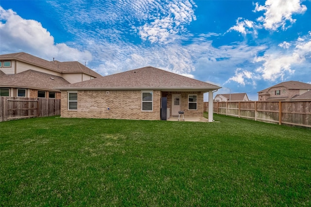 back of house with a lawn and a patio