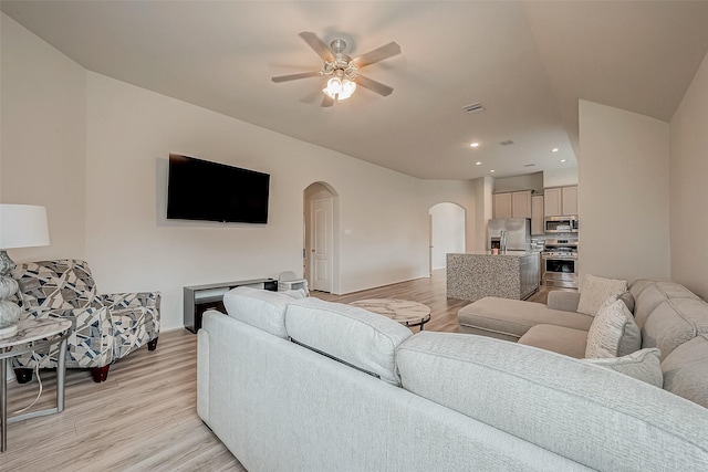 living room with light hardwood / wood-style flooring and ceiling fan