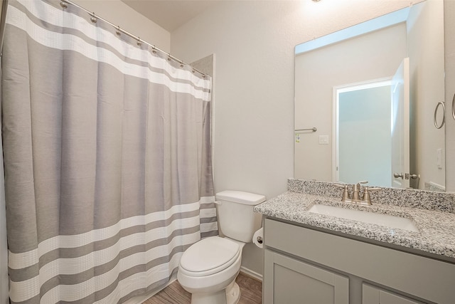 bathroom featuring hardwood / wood-style floors, vanity, and toilet