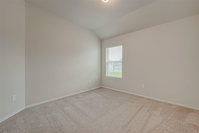 carpeted spare room featuring lofted ceiling