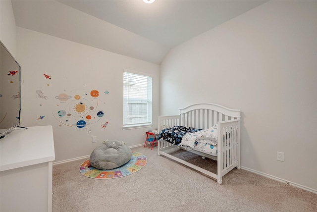 carpeted bedroom featuring a nursery area and lofted ceiling