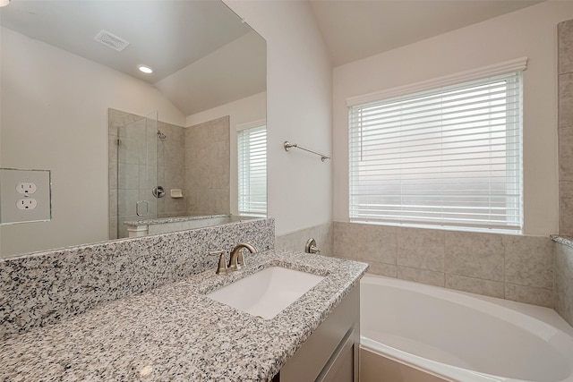 full bathroom featuring separate shower and tub, vanity, vaulted ceiling, and toilet