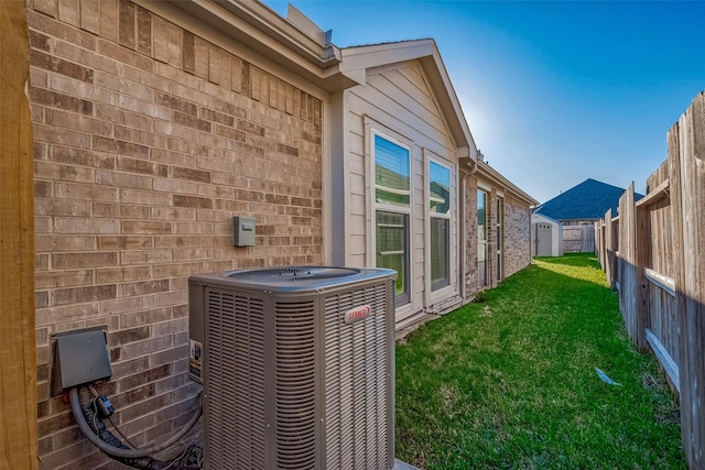 view of side of home with a lawn and cooling unit