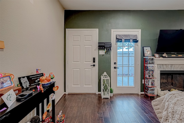 foyer entrance featuring a fireplace and dark hardwood / wood-style flooring