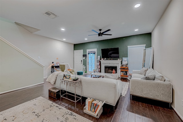 living room with ceiling fan, a fireplace, and dark hardwood / wood-style floors