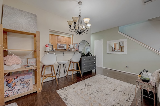 home office with dark hardwood / wood-style flooring and an inviting chandelier