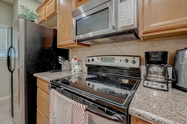 kitchen featuring light brown cabinets, tasteful backsplash, black range with electric stovetop, and light stone counters